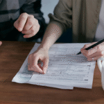 Zwei Personen überprüfen gemeinsam Steuerunterlagen und machen Notizen – Symbol für Verantwortung und Haftung bei finanziellen Angelegenheiten.